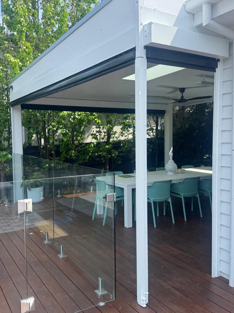 This project in Cheltenham required a tailored approach to navigate a tricky corner on a pergola. We utilised a custom removable post on the corner to allow a clear walk-way when the blinds are retracted and post is removed. The client chose a 99% blockout mesh for wind, rain and sun protection without sacrificing their view. The job also required custom Colorbond flashings to infill the gap above the pelmets due to the pitch of the roof.
